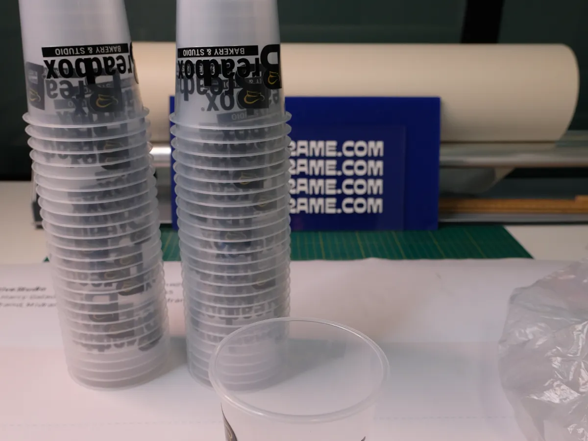 Stacks of branded clear cups for a bakery