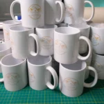 Bulk order of white mugs printed with a guest house logo